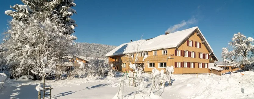 Dasselbe Haus tief verschneit an einem klaren Wintertag
