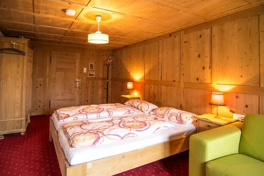 Zweites Schlafzimmer mit derselben Holzvertäfelung und Nachttischlampen
