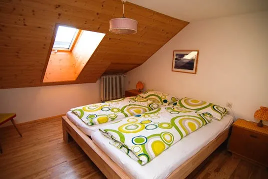 Helles Schlafzimmer mit südseitigem Dachfenster und Doppelbett